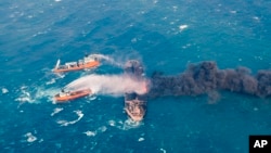 FILE - Firefighting boats work to put on a blaze on the oil tanker Sanchi in the East China Sea off the eastern coast of China, Jan. 10, 2018.