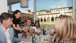 Antoinette Mazzaglia, of Taste Florence, shows tourists how to read a wine label at the Golden View Open Bar overlooking Florence