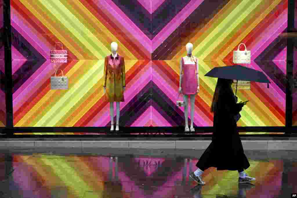 A pedestrian walks past a shop in New Bond Street as it rains in London.