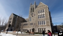 FILE - Students walk on the Boston College campus, Feb. 17, 2021.