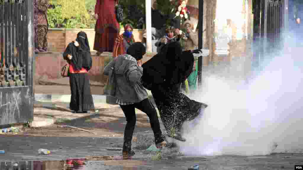 Women react to tear gas during a protest at Al-Azhar University in Cairo, Dec. 11, 2013. (Hamada Elrasam for VOA)