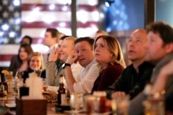 FILE - People watch as members of the House of Representatives vote on the first article of impeachment against President Donald Trump, displayed on television monitors at the Hawk 'n' Dove bar on Capitol Hill in Washington, Dec. 18, 2019.