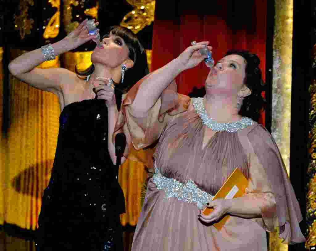 Members of the cast of "Bridesmaids" Rose Byrne and Melissa McCarthy drink a toast to Martin Scorsese, whose film "Hugo" won several awards. (AP)