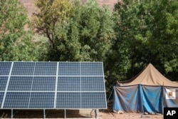 A tent for people displaced by the 2023 earthquake sits next to solar panels, in the Atlas mountain village of Tinmel, Morocco, Sept. 5, 2024.