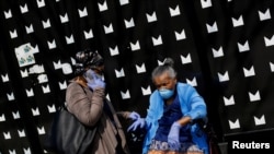 People seen along along 53rd Street wear personal protective equipment during the global outbreak of coronavirus disease (COVID-19) in Chicago, Illinois, April 7, 2020.