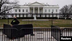 A Secret Service officer maintains a watch on the 22nd day of a partial government shutdown at the White House in Washington, Jan. 12, 2019. 