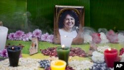 FILE - A picture of Berta Caceres sits on an altar in her honor during a demonstration outside Honduras' embassy in Mexico City, June 15, 2016. 