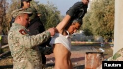 Iraqi army soldiers detain a person suspected of belonging to Islamic State militants during a battle with Islamic State militants in Arabi neighborhood in Mosul, Iraq, Jan. 26, 2017.