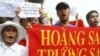 FILE - Vietnamese protesters carry a banner with a Vietnamese slogan reading, "Paracel islands and Spratly islands belong to Vietnam," during a protest demanding China to stay out of their waters, in Hanoi, Vietnam.