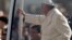El sacerdote Fabián Báez (abajo) viaja junto al papa Francisco en el papamóvil.