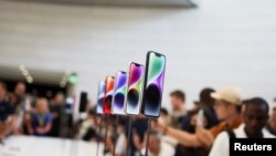 Guests look at the new iPhone 14 at an Apple event at their headquarters in Cupertino, California, U.S. September 7, 2022. REUTERS/Carlos Barria