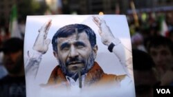 Seorang pendukung Hizbullah di Lebanon memegang poster bergambar Presiden Iran Mahmoud Ahmadinejad.