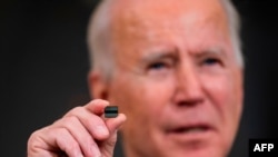 US President Joe Biden holds a semiconductor during his remarks before signing an executive order on the economy in the State Dining Room of the White House on Feb. 24, 2021, in Washington, DC. 