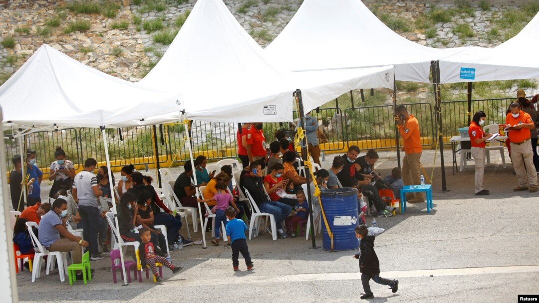 Migrantes centroamericanos, entre ellos menores de edad, que fueron expulsados de EE. UU. en base al Título 42 esperan bajo un toldo en el Instituto Nacional para la Migración en Ciudad Juárez, México el 17 de agosto de 2021. 