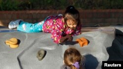 En esta foto de archivo dos pequeñas juegan en un patio infantil en las instalaciones de Head Start. Frederick, Maryland.