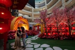 Two women take photos under the Chinese New Year lantern decorations at a shopping mall in Kuala Lumpur, Malaysia, on Jan. 16, 2021.