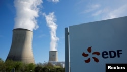 FILE — The logo of Electricite de France, EDF — one of the companies vying to open the first nuclear power plant in Ghana — is seen in front of cooling towers at the entrance of the nuclear power plant site, in Civaux, France, on March 19, 2024. 