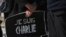 Warga Perancis di Jepang memegang tanda bertuliskan "Saya Charlie" pada penghormatan untuk para korban penembakan di kantor koran Charlie Hebdo di Paris (7/1).