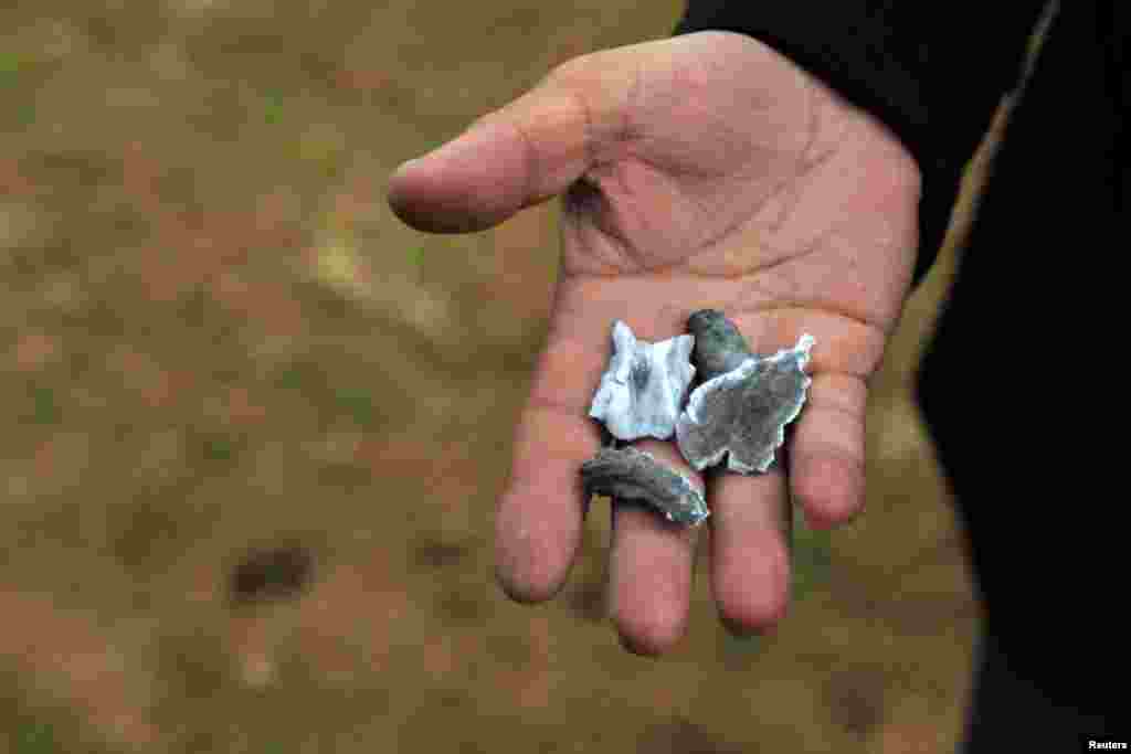 A man holds shrapnel from a missile launched by Iran on U.S.-led coalition forces on the outskirts of Duhok ,Iraq, Jan. 8, 2020.