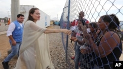 FILE - Angelina Jolie greets a group of Venezuelan migrants at a United Nations-run camp in Maicao, Colombia, on the border with Venezuela, June 8, 2019.