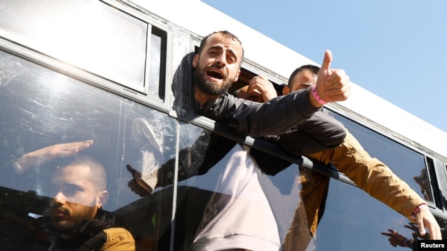 Los prisioneros palestinos liberados hacen un gesto desde un autobús después de ser liberados por Israel como parte de un intercambio de rehenes-prisioneros y un acuerdo de alto el fuego en Gaza entre Hamas e Israel, el 15 de febrero de 2025. REUTERS/