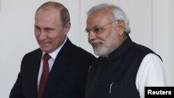 Russian President Vladimir Putin (L) and India's Prime Minister Narendra Modi arrives for a photo opportunity ahead of their meeting at Hyderabad House in New Delhi, December 11, 2014.