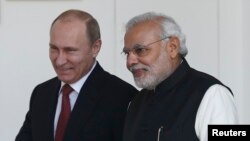 Russian President Vladimir Putin (L) and India's Prime Minister Narendra Modi arrives for a photo opportunity ahead of their meeting at Hyderabad House in New Delhi, December 11, 2014.