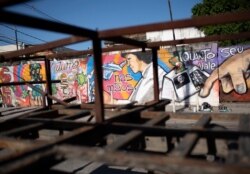 Un mural del artista de graffiti Angelo Campos, de 39, en honor de los trabajadores de salud en Río de Janeiro, Brasil, es visto a través de una estructura abandonada de metal, el 21 de mayo de 2020. Campos ha perdido dos familiares por el COVID-19.