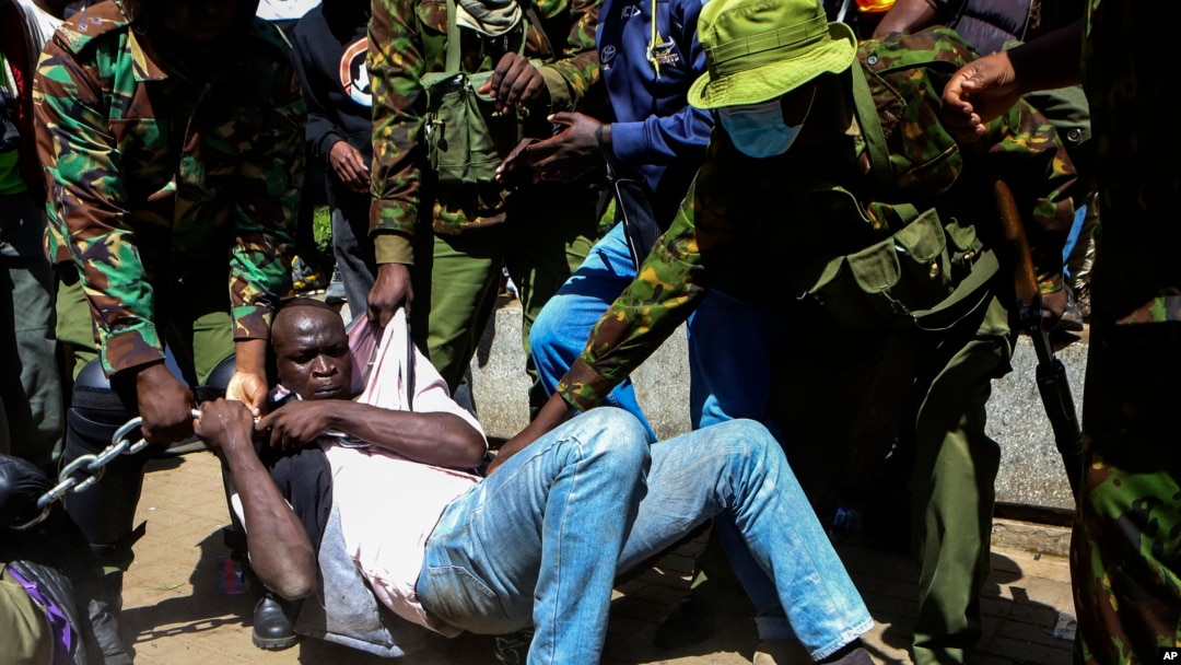 Police arrest a protester who has chained himself during protests against abductions in Nairobi, Dec. 30, 2024. 