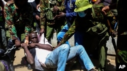 Police arrest a protester who has chained himself during protests against abductions in Nairobi, Dec. 30, 2024. 