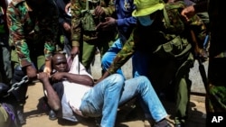 Police arrest a protester who has chained himself during protests against abductions in Nairobi, Dec. 30, 2024. 