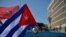 Des Cubains passent devant l'ambassade des États-Unis lors d'un rassemblement appelant à la fin du blocus américain contre leur pays, à La Havane, le 28 mars 2021. 