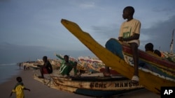 Niños sentados en piraguas, embarcaciones senegalesas utilizadas por pescadores e inmigrantes, en la playa de Fass Boye, Senegal, el martes 29 de agosto de 2023.