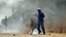 In this photo taken Monday, Sept 3, 2012, sacked gold miners set up a burning barracade at Gold One International's mine east of Johannesburg. 