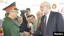 Wakil Menteri Pertahanan Vietnam Nguyen Chi Vinh (kiri) berjabat tangan dengan Dubes Vietnam David Shear dalam upacara peresmian kerjasama AS-Vietnam untuk pembersihan sisa pencemaran akibat Dioxin di Vietnam (9/8).