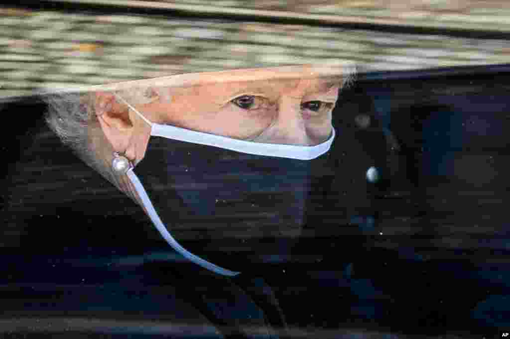 Britain&#39;s Queen Elizabeth II follows the coffin of her late husband Prince Philip, in a car as it makes it&#39;s way past the Round Tower during his funeral inside Windsor Castle in Windsor, England, April 17, 2021.