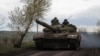 Ukrainian servicemen ride in a tank along a road in the town of Chasiv Yar, amid Russia's attack on Ukraine, near a front line in Donetsk region, Ukraine April 22, 2023. 