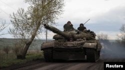 Ukrainian servicemen ride in a tank along a road in the town of Chasiv Yar, amid Russia's attack on Ukraine, near a front line in Donetsk region, Ukraine April 22, 2023. 