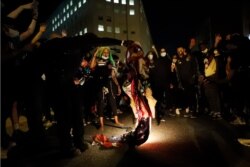 Manifestantes observan incendiarse una bandera de EE.UU. mientras la gente se reúne para protestar la muerte de George Floyd, el domingo 31 de mayo cerca de la Casa Blanca, en Washington D.C.