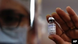 A nurse shows to the press a vial of Russia's Sputnik V vaccine for COVID-19 during a vaccination campaign inside River Plate stadium in Buenos Aires, Argentina, Tuesday, Feb. 2, 2021. (AP Photo/Natacha Pisarenko)