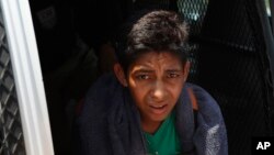 A Central American migrant detained by Mexican immigration agents looks out from a van on the highway to Pijijiapan, Mexico, April 22, 2019.