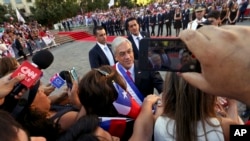 Presiden Chile Sebastian Pinera menyambut para pendukungnya di luar istana kepresidenan, La Moneda, pada hari pelantikan di Santiago, Chile, Minggu, 11 Maret, 2018.