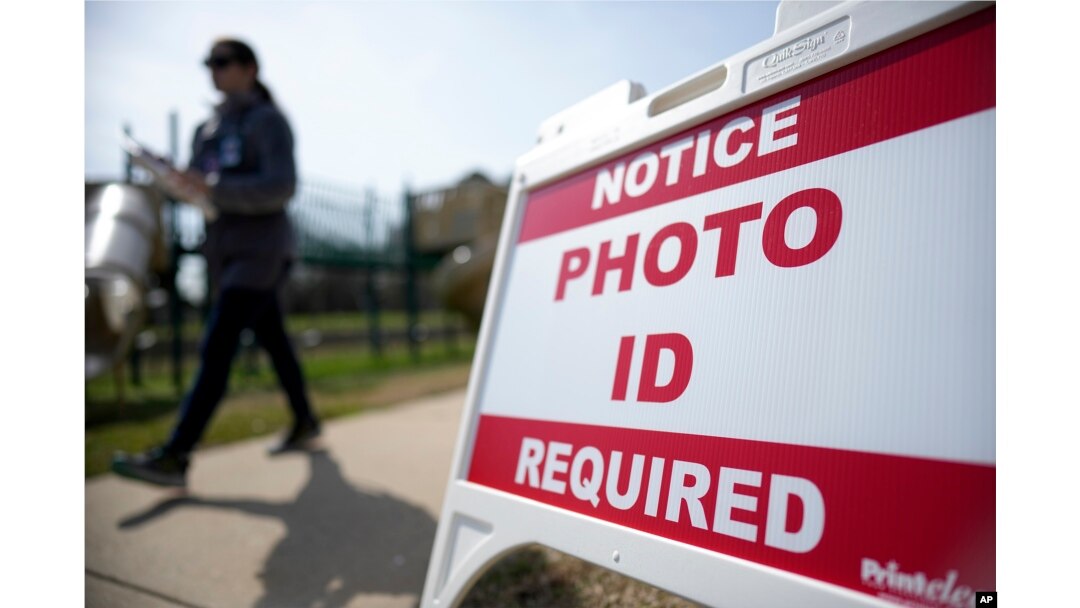 FILE - A Super Tuesday voter walks past a sign requiring photo identification at a polling location in Mount Holly, North Carolina, March 5, 2024.