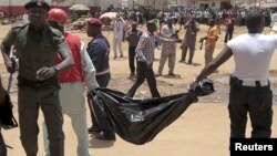 Ma'aikatan ceto dauke da gawar wani, bayan hare haren da aka kai ofishin jaridar This Day a Abuja a ranar Alhamis