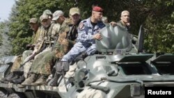 FILE - Members of a special military unit of the separatist self-proclaimed Lugansk People's Republic drive an armored vehicle as they take part in a drill in Luhansk, Ukraine, July 10, 2018.