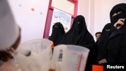 Women wait to receive supplemental nutrition shakes, at malnutrition treatment ward of al-Sabeen hospital in Sana'a, Yemen, Feb. 24, 2021. 