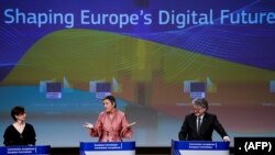 FILE: European Commission Executive Vice-President Margrethe Vestager (C) and EU Commissioner for Internal Market Thierry Breton (R) give a press conference on Artificial Intelligence (AI) at the European Commission headquarters in Brussels on February 19, 2020.