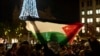 Seorang demonstran pro-Palestina membentangkan bendera Palestina dalam aksi di Amsterdam, pada 13 November 2024. (Foto: AP/Bram Janssen)