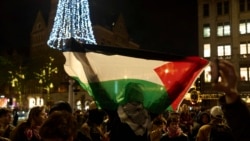 Seorang demonstran pro-Palestina membentangkan bendera Palestina dalam aksi di Amsterdam, pada 13 November 2024. (Foto: AP/Bram Janssen)