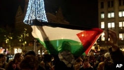 Seorang demonstran pro-Palestina membentangkan bendera Palestina dalam aksi di Amsterdam, pada 13 November 2024. (Foto: AP/Bram Janssen)